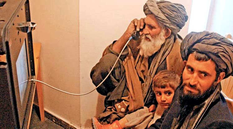 Cabul (Afghanistan): pap videotelefona al figlio recluso (per terrorismo) nella prigione della base aerea USA di Bagram  (nord di Cabul), al suo lato il nipote e l'altro figlio; fonte Carranca