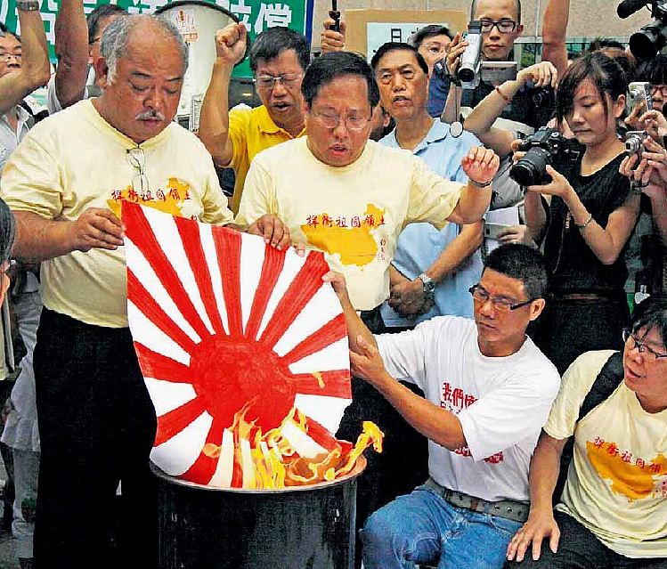 Cinesi di Hong Kong bruciano "bandiera imperiale giapponese" in ricordo dell'invasione giapponese e in protesta per la detenzione di un comandante di una nave (cinese) bloccata (dai giapponesi) al largo delle isole Diaoyu (contese dalle due nazioni); fonte Kin