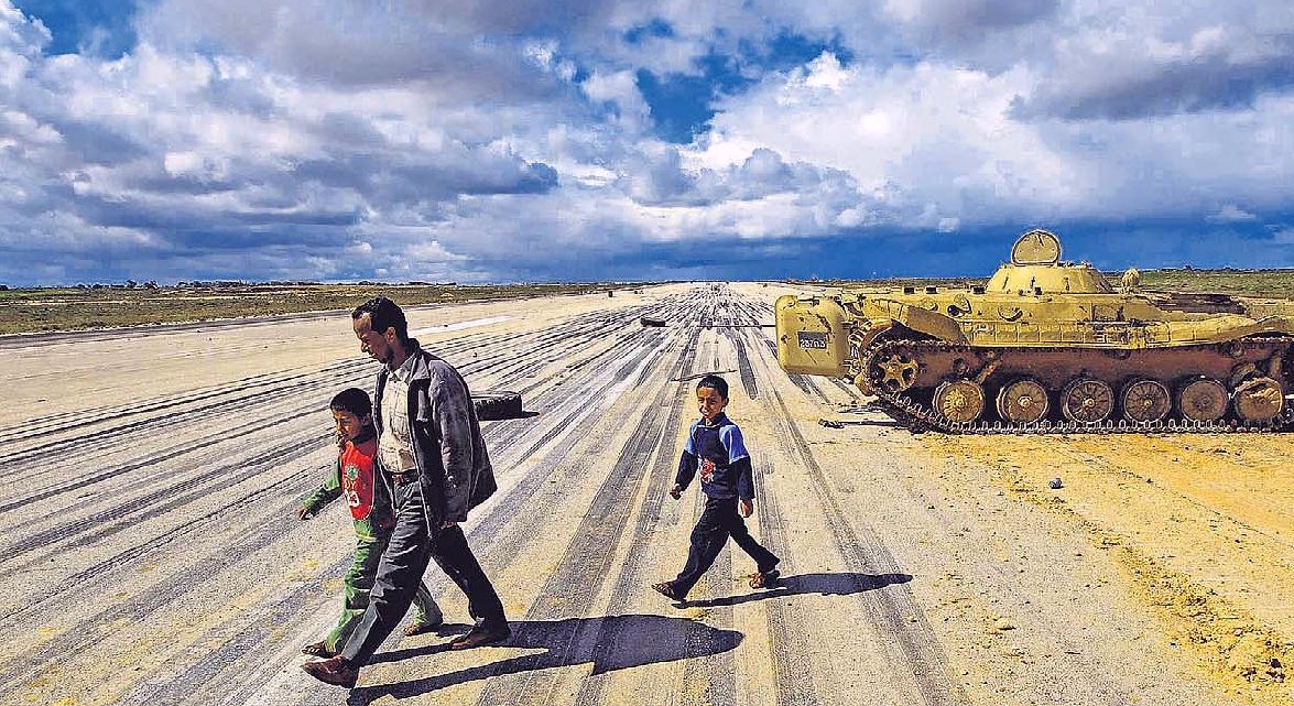 Pap con 2 figli attraversa pista dell'aeroporto militare di Al Abrak (Libia)