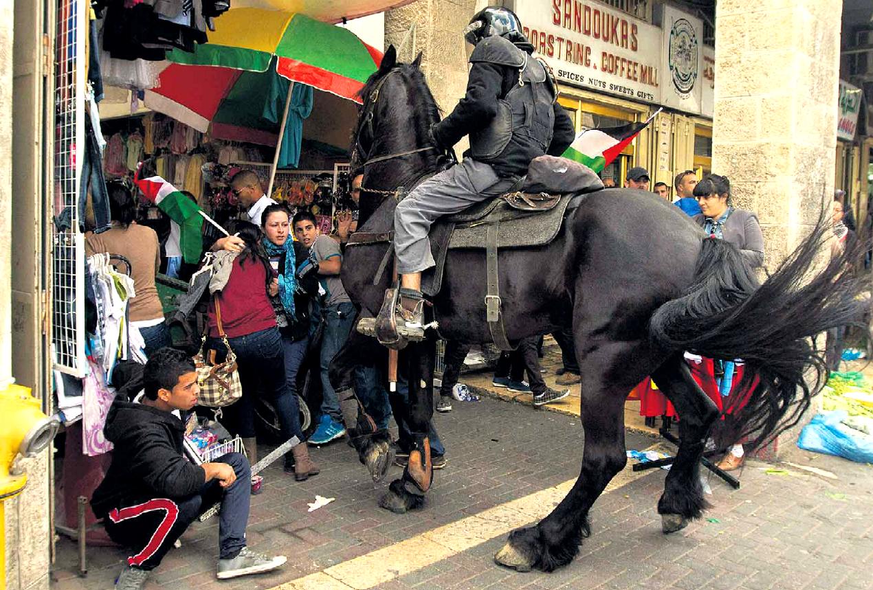 poliziotto israeliano disperde palestinesi in protesta a Gerusalemme, alla "Porta di Damasco", nell'anniversario della creazione dello Stato di Israele; fonte Guez