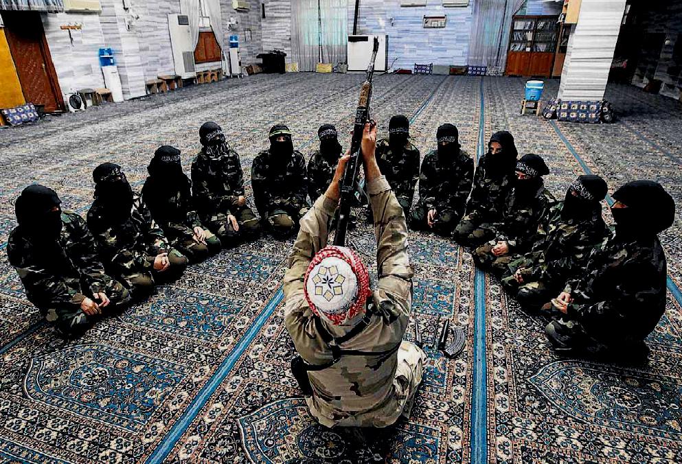Aleppo (Siria), capo dei ribelli insegna a donne, in una moschea, l'uso del mitragliatore; fonte Muzaffar
